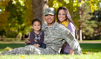family of 3 smiling at camera, father in military uniform